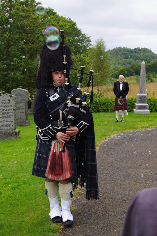 A Scottish piper bagpipes in a traditional highland kilt
